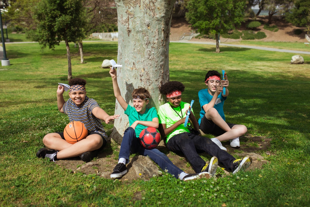 kids sitting next to a tree